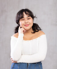 Portrait of positive young girl in casual clothes posing in studio