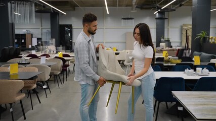 Young couple choosing dining chair in furniture store on Black Friday