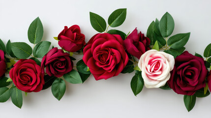 Obraz premium A beautiful arrangement of deep red roses and one pink rose with vibrant green leaves is displayed against a bright white backdrop for elegant decoration.