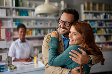 Portrait of embraced couple in pharmacy.