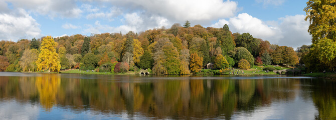 Panoramic photo of the autumn colours around the lake at Stourhead gardens in Wiltshire