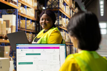 Worker wearing safety vest manages packages and process orders in compact distribution hub. This...