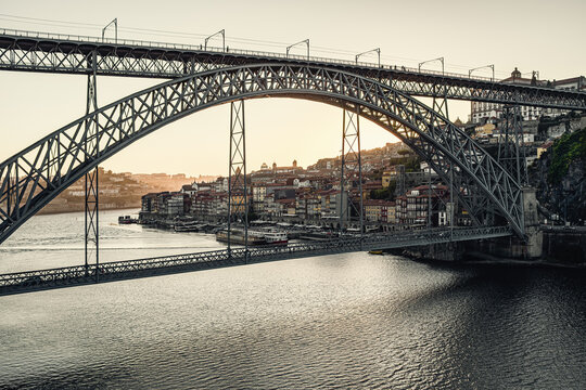 Porto cityscape with dom luis i bridge spanning douro river at sunset