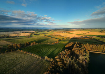 Aerial view of countryside fields and green hills at sunset. Beautiful rural landscape and nature background. Beecraigs Country Park, West Lothian, Scotland