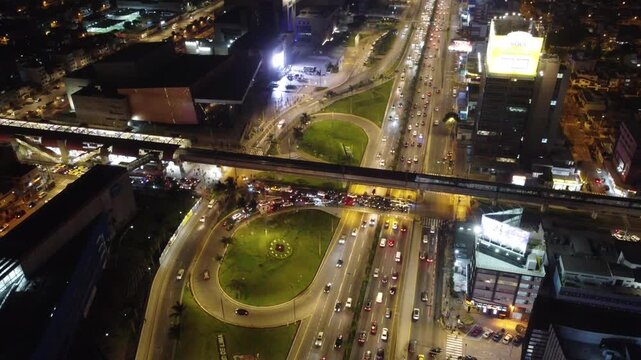 Heavy traffic moving through a busy highway interchange in lima, peru, illuminated by city lights