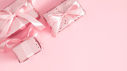 Tender composition of gift boxes with pink satin ribbons on pink background. Perfect for web...