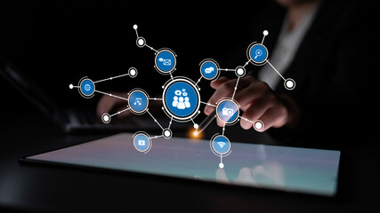 A user interacts with a tablet displaying a digital network visualization featuring icons for communication and multimedia, symbolizing modern connectivity and digital engagement. Tessel