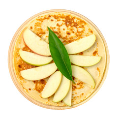 Overhead shot golden pancakes with apple slices and a green leaf, on a wooden plate