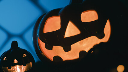 Halloween pumpkin lit up at night in silhouette in the scary garden