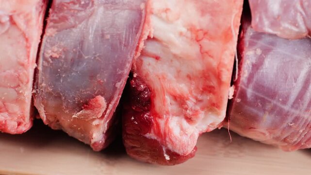 Fresh beef ossobuco steak with salt, spices and herbs on textured background, bones. 