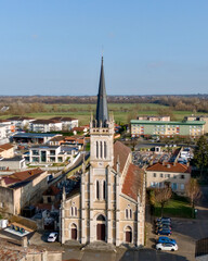 Naklejka premium Beautiful church with high spire surrounded by city buildings in Macon France 