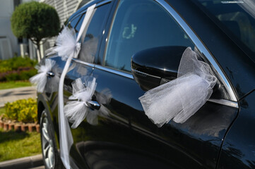 Decorated wedding car with flowers and ribbons. Wedding vehicle decorations for bride and groom. Car for wedding. 
