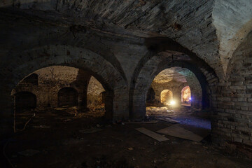 Dark and creepy vaulted red brick cellar under old castle
