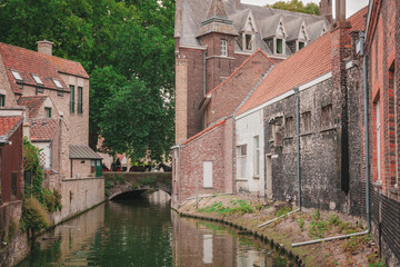Naklejka premium Bruges, Belgium. Brugge. View of a river with a medieval bridge in the background.