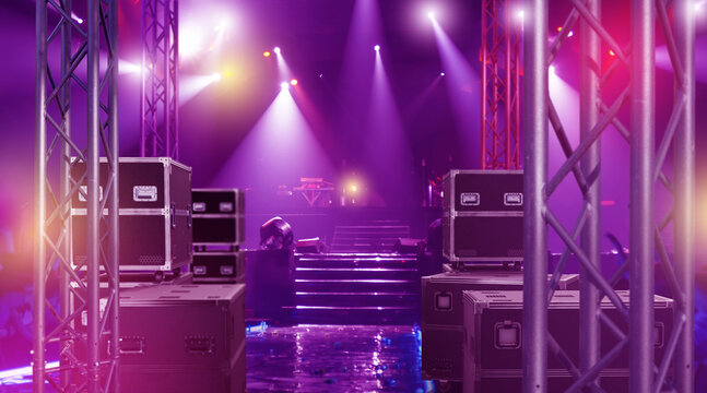 Stage with professional lighting, sound equipment and flight cases prepared for live concert or event production, concept of music show, entertainment and performance. Concert.