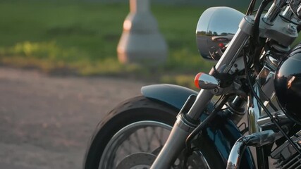 close up of motorcycle front wheel and chrome parts during road adventure trip, shiny metal reflecting evening light with blurred green background, capturing essence of biker lifestyle - Powered by Adobe