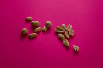Scattered peanuts on pink background colorful minimal food concept