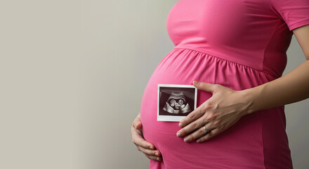 Pregnant woman in pink dress showing ultrasound image of twin babies on her baby bump, concept of pregnancy, reproductive science, and future family