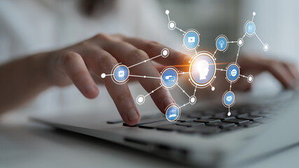 A close-up view of a person hand typing on a laptop, surrounded by digital icons representing various aspects of technology, communication, and connectivity in a modern workspace. Tessel