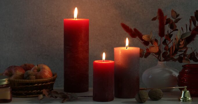Composition with different burning candles on table against gray background. Autumn atmosphere