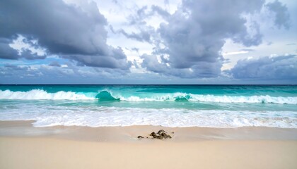 Wide sandy beach meets turquoise ocean under dramatic sky