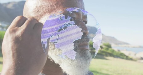 Mature man closing eyes starting tech globe wrapping head inserting earbud and gazing horizon - Powered by Adobe