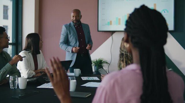 Black businesswoman with hand raised during presentation in meeting room at office