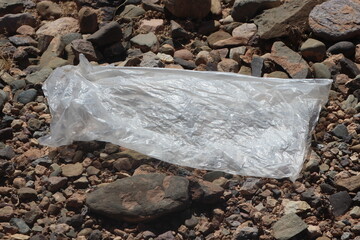 A close up of a transparent plastic bag lying on the ground