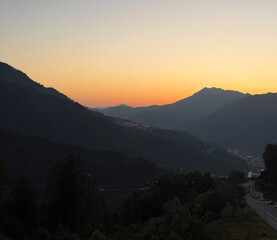 Twilight colors illuminate the mountains as the sun sets, creating a serene scene