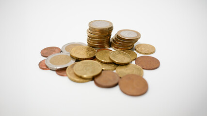 A heap of Euro coins on a white desk. Savings and investment concept.