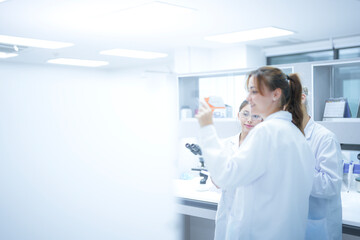 A scientist uses an augmented reality system to share a live microscopic view of a slide with remote colleagues, enabling real-time global consultation and AI-assisted analysis.