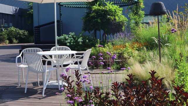 There are parasols and chairs in the urban garden created on the rooftop of a building in the city center.도심의 건물 옥상에 만든 도시정원에 파라솔과 의자가 있습니다.