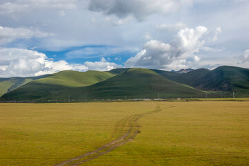 Vast grassland with rolling hills under a cloudy sky