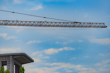 Against the backdrop of blue sky and white clouds, the working site of tower cranes at construction sites
