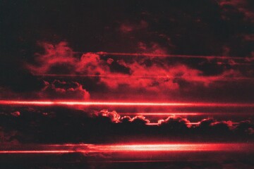 Dramatic red clouds and horizontal light streaks in a dark sky
