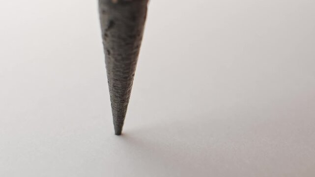 Close up of pencil with the graphite tip cracking under pressure. Slow motion of a pencil lead breaking and shattering symbolizing stress or crisis at work or school, frustration, or a simple mistake.