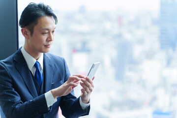 スマートフォンを使う40代の会社員 © taka