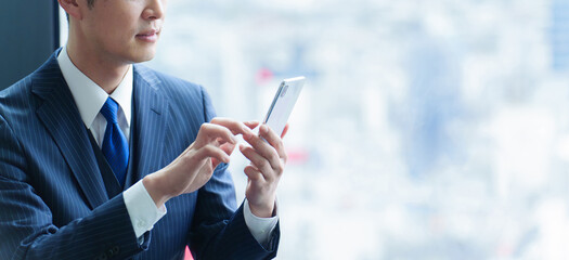 スマートフォンを使う40代の会社員の手元
