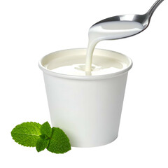 Close-up of yogurt being poured from spoon into a white container with mint, isolated