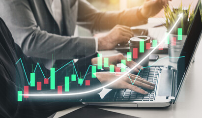 Two business professionals work together in a modern office setting, analyzing financial data on a laptop while a stock market graph overlays the scene. Impute