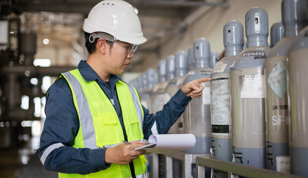 Engineer inspecting SF6 gas cylinders in industrial facility. Focus on safety, pressure container inspection, hazardous material management, and workplace safety checklist documentation