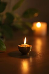Golden candle flame burning in a brass lamp with soft warm light and gentle bokeh in the background, symbolizing peace, spirituality, meditation, and serenity in a dark tranquil atmosphere with natura