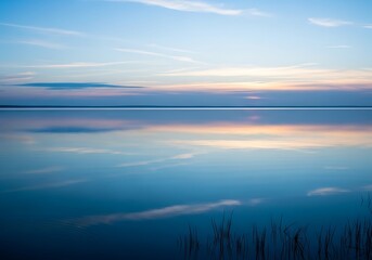 Fototapeta premium A tranquil evening landscape, with water reflecting the soft sunset sky
