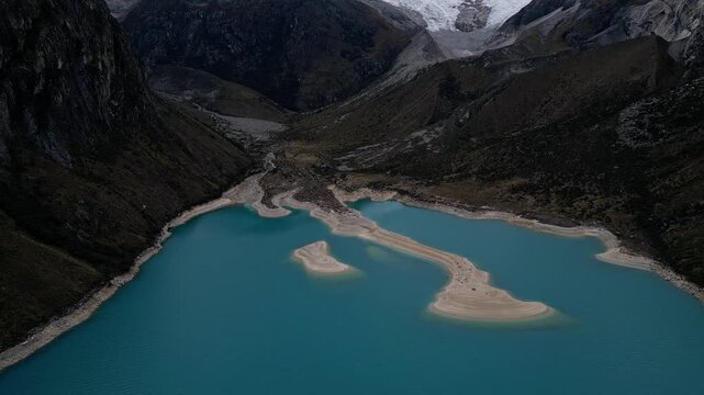 Huaraz, Peru: Drone footage of laguna paron in Caraz of Huaraz region, Peru. Taken with backward and tilt up motion, showing the landscape of lake surrounded by Cordillera blanca mountain