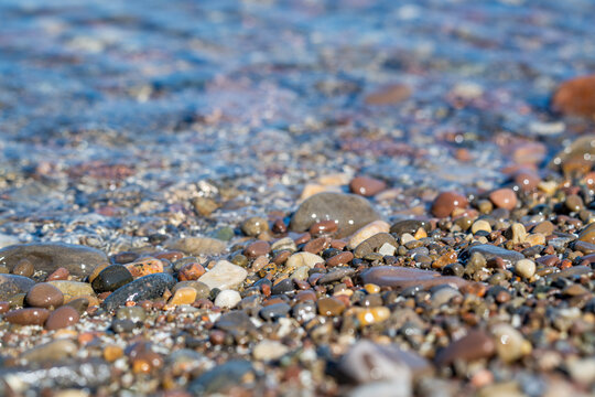 Lake Ontario shoreline with colorful stones and crystal clear freshwater.  
