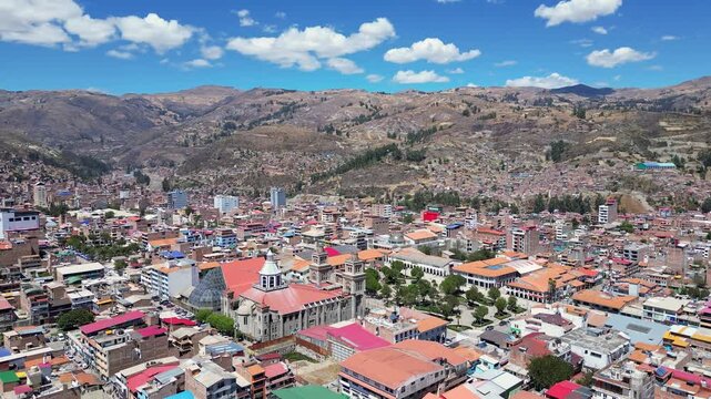Huaraz, Peru: Aerial drone footage of Huaraz Plaza de Armas. Taken with forward motion, showing the cathedral and residential area of famous travel destination surrounded by mountains on sunny day