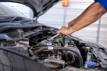 Fototapeta premium Mechanic's hands repairing car engine with wrench