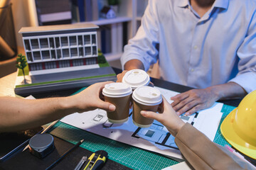 A group of engineers and architects collaborate on a construction project, discussing ideas and sharing technical plans to design innovative modern buildings in a creative teamwork environment.