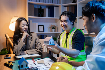 Architects and engineers work together in an office to review blueprints, exchange ideas, and refine their building plans for a contemporary construction project in an urban setting.