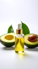 A glass bottle of yellow oil with dropper is centered, in front of avocado halves, with green leaves behind. Bright white background
